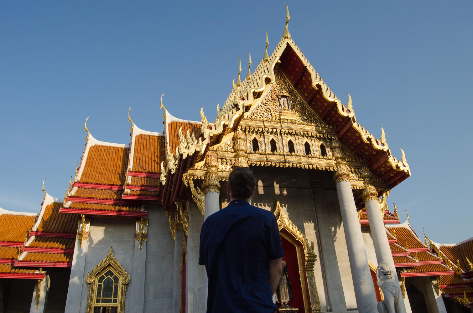 Introvert man alone staring at the Marble Temple in Bangkok