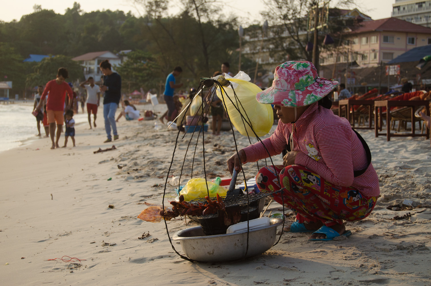 Woman selling grilled squid in Sihanoukville beach, Cambodia